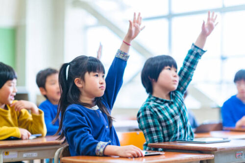 積極的に手を挙げる小学生